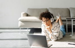 Étudiant portant un casque et écoutant un cours vocalisé sur son ordinateur portable.